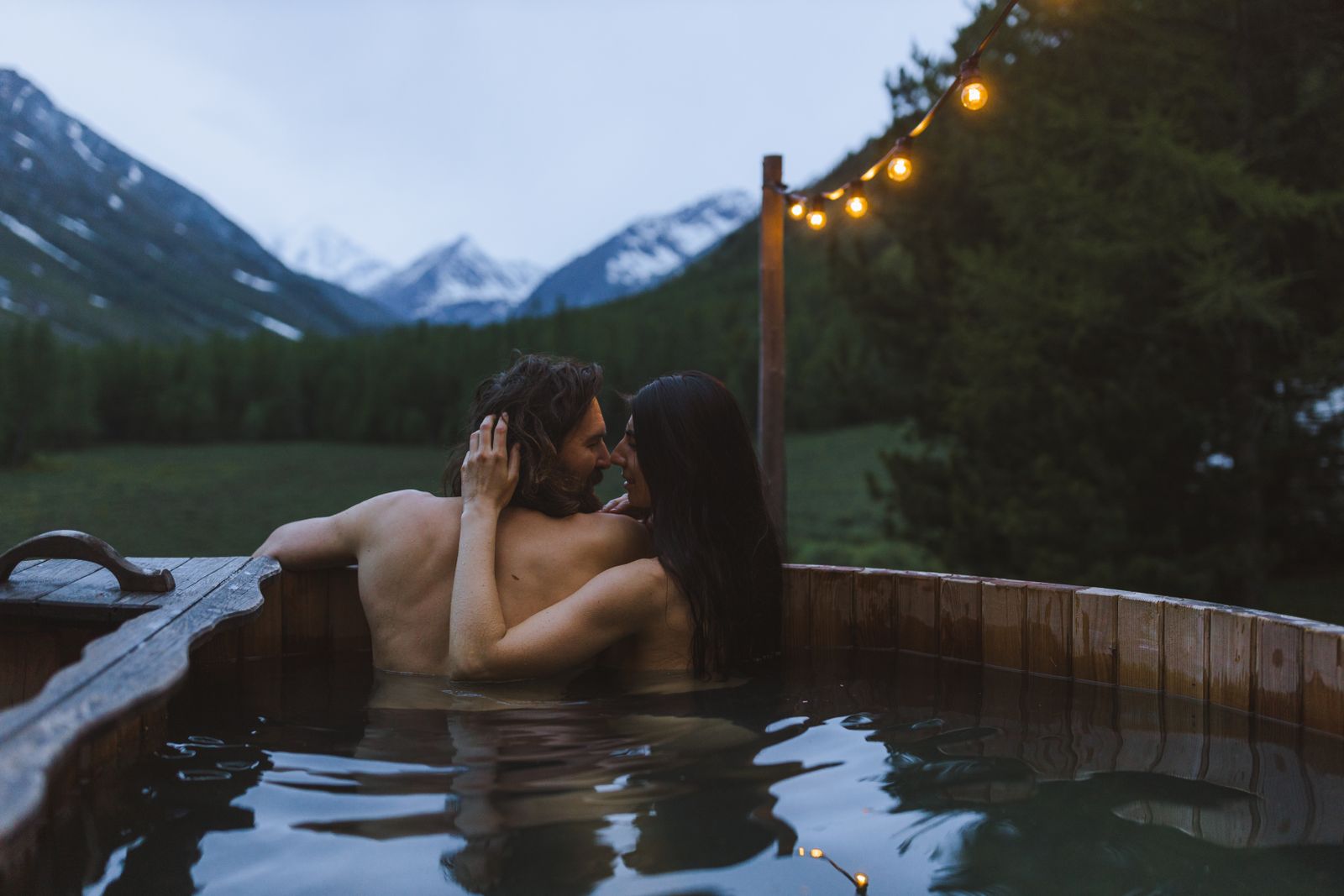 Wooden hot tub in the forest in the evening